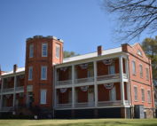 Two story historic brick building with flag bunting handing from eaves.
