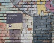 A painted brick wall with a sign that reads "accessible entry."